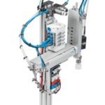 Mô-đun Pick&Place nhặt một phôi nắp gia công từ thanh trượt cung cấp vật liệu và đặt nó vào thân phôi.